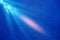 Diagonal diffused light blue and pink beam of light on a blue structural background