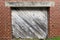 Diagonal faded wooded shipping receiving loading dock door red brick building alley