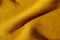 Diagonal fold of mustard yellow woolen fabric