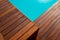 Diagonal line of exotic hardwood in detail decking around the blue water swimming pool corner