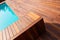 Diagonal lines of wood tiles, ipe exotic hardwood around the blue water swimming pool