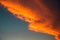 Diagonal orange stormy cloud in sunset light at blue sky background as abstract nature wallpaper