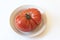 Diagonal organic red heritage tomato on a shallow dish, centered