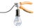 Diagonal pliers cutting wire from lightbulb, saving energy conce