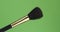 Diagonal rotation of the makeup brush. Isolated on green.