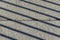 Diagonal shadow lines on concrete surface with horizontal line of separation of concrete slabs in the center.