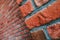 Diagonal side angle of a red brick wall corner. Close up view of cracked weathered brickwork material. Modern interior design,