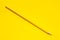 Diagonal yellow sharp wooden pencil on a bright yellow background, isolated, copy space, mock up