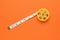 Diagonally unwound measuring tape on an orange background. Flat lay