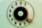 Dialing disc of an old green telephone with round holes and numbers. Macro shot of retro rotary phone with transparent