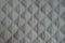 Diamond pattern on white quilted fabric from above