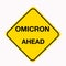 Diamond shaped yellow traffic warning sign with Omicron Ahead as the message