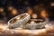 Diamond-studded wedding rings displayed against a golden background with bokeh effect