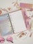 Diary opens with white and holographic page. Pink planner with cute stationery photographing in flatlay style. Top view of pink