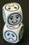 Dice with opposite sad and happy emoticon sides