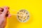 Dice in white bowl with chopsticks on yellow background