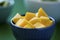 Diced mango in blue bowl, with Thai food background