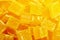 Diced mango dried fruits texture background, top view. Dehydrated mango chips dices, sweet food closeup