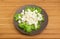 Diced mozzarella cheese on lettuce leaves on brown dish