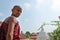 Dickwella, Sri Lanka, 04-15-2017: Young Buddhist monk on the background of a Buddhist pagoda looks at the camera