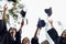 We did it. A group of smiling college graduates celebrating their graduation.