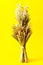 Didukh or sheaf of rye and dry cereals on yellow background. The symbol of the spirit of the guardian of the house