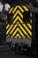 Diesel freight train locomotive with yellow and black warning hazard safety diagonal stripes painted on.