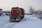 Diesel powered locomotive in the snow. Winter day on the railway in Russia