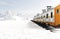 Diesel train (eastern express) in motion on snow covered railway platform over snowy landscape. Transportation