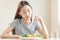 Diet in bored face, unhappy beautiful asian young woman, girl on dieting, holding fork in salad plate, dislike or tired with eat