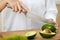 Diet. Female Hands Cutting Avocado In Kitchen.