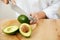 Diet. Female Hands Cutting Avocado In Kitchen.