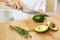 Diet. Female Hands Cutting Avocado In Kitchen.