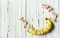 Diet healthy concept. Banana with measuring tape on white wooden