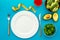 Diet program concept. Empty plate, measure tape and vegetables on blue background top view mockup