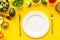 Diet program concept. Empty plate, measure tape and vegetables on yellow background top view mockup
