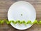 Diet. Suffering from anorexia. Cropped image pea on white plate, with fork and measuring