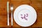 Diet. Violet pills on round white plate and fork with knife