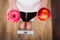 Diet. Woman Measuring Body Weight On Weighing Scale Holding Donut and apple. Sweets Are Unhealthy Junk Food. Dieting, Healthy Eat