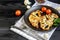 Dietary cauliflower steak in the oven in a grill pan. Nearby are cherry tomatoes, a sprig of mint, lime, peppercorns. Dietary