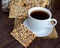 Dietary crunchy cracker with cereals (sunflower seeds, flax and sesame) and a cup of tea on a dark