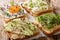 Dietary fitness toast with hummus, avocado, feta cheese, microgreen and egg closeup. horizontal