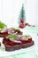 Dietary sandwiches with herring, boiled beets, red onion on rye bread on a white wooden background.