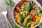 Dietary vegetarian salad of baby spinach, corn, cherry tomatoes and onions dressed with olive oil close-up in a bowl. Horizontal