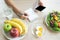 Dieting and calories control for wellness. Woman using smartphone calculate calories of food in breakfast during dieting.