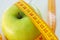 Dieting concept. Green apple with measuring tape. Green apples measured the meter, sports apple