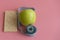 Dieting Concept Green Apple and waist line on a pink background