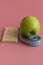 Dieting Concept Green Apple and waist line on a pink background. vertical photo