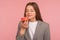 Dieting and junk food. Portrait of hungry woman, office worker in business suit smelling sweet doughnut