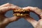 Dieting or low calorie food concept. Close up of woman hands holding oatmeal breakfast cookie sandwich with dark chocolate